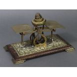 A late Victorian brass embossed letter scale mounted on an oak platform base, & with five brass