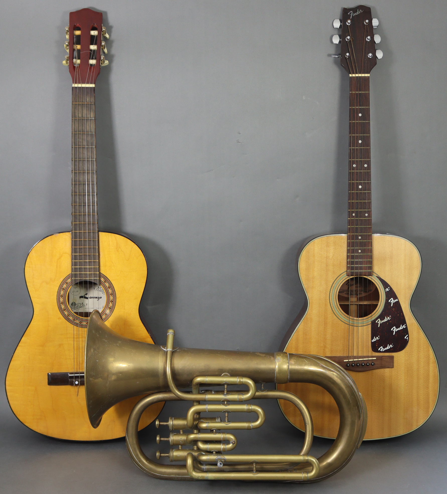 A Fender six-string acoustic guitar, another acoustic guitar (one with case); & a brass Euphonium (l
