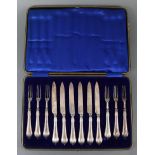 A set of six Edwardian silver tea knives & forks with loaded stylised handles, London 1901, cased.