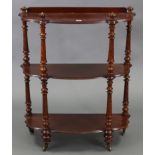 A Victorian-style mahogany serpentine-front three-tier standing open bookcase on spiral-twist &
