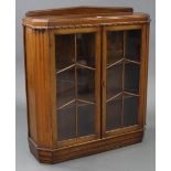 A mid-20th century oak bookcase with two adjustable shelves enclosed by pair of glazed doors, & on