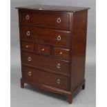 A Stag “Minstrel” mahogany-finish upright chest fitted with an arrangement of three short & four