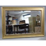 A large gilt frame rectangular wall mirror with rope-twist border & inset bevelled plate, 39½” x