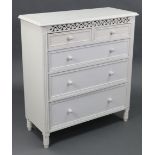 A white painted wooden chest with pierced & carved frieze, fitted two short & three long graduated