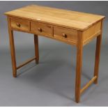 A light oak dressing table fitted three frieze drawers, & on square tapered legs with plain