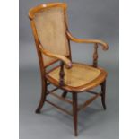 An early 20th century beech elbow chair inset woven-cane panel to the seat & back, & on round