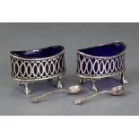 A pair of pierced oval silver salt cellars in the mid-18th century style, with matching spoons,