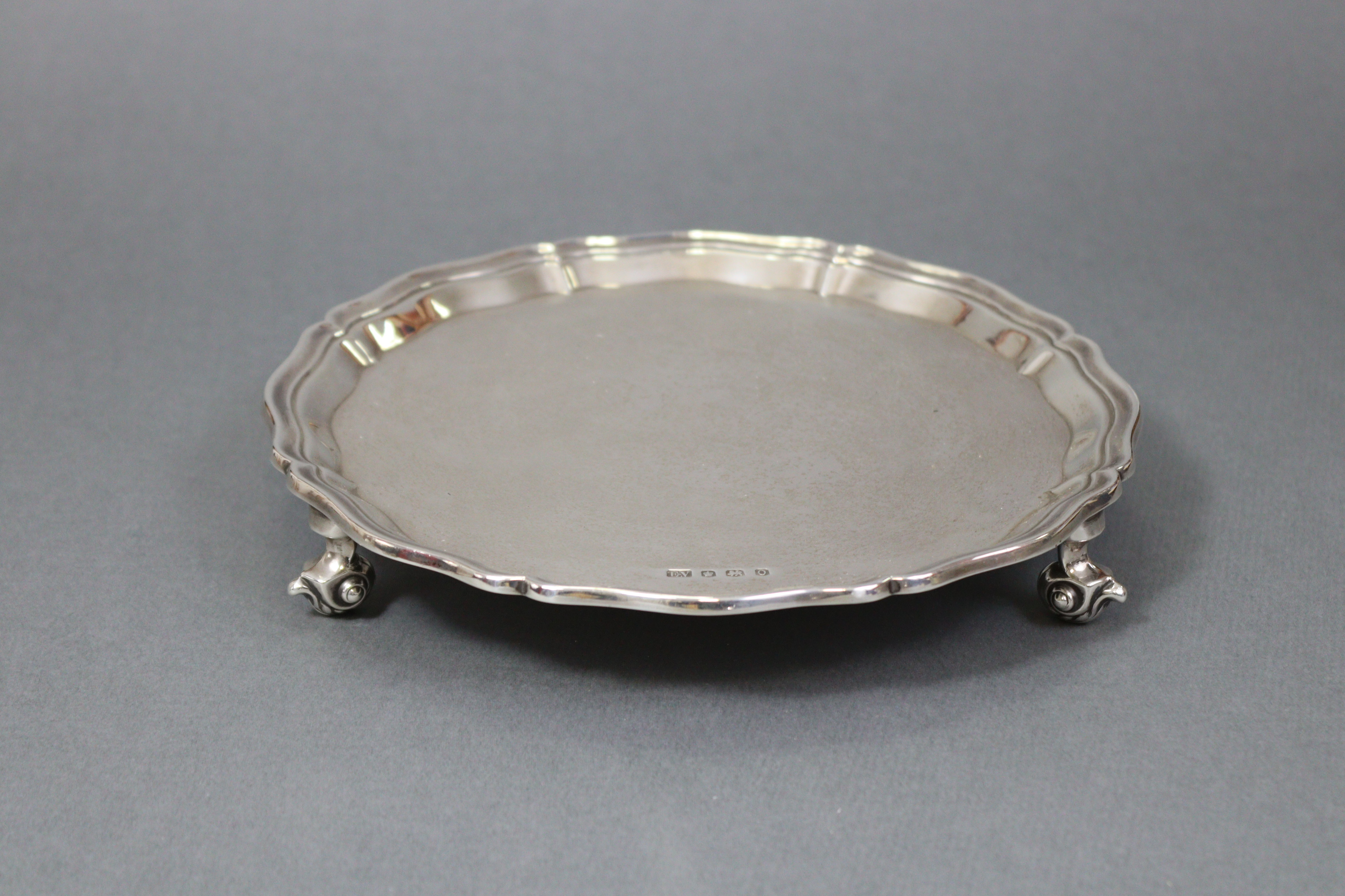 A George V silver waiter with raised pie-crust border, on three leaf-scroll feet, 8” diam.; - Image 4 of 4