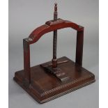 A 19th century mahogany book press with central wooden screw supported by a solid wood frame with