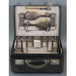 A vintage leather travelling dressing case with fully fitted interior comprising: seven glass