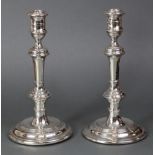 A pair of silver candlesticks with slender baluster columns & on wide circular bases with engraved