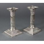 A pair of late Victorian silver desk candlesticks, the round stop-fluted columns with composite