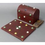 A dome-top stationery box covered in dark red morocco, the hinged lid & front inset with coloured