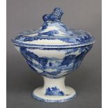 A 19th century pearlware circular tureen & cover with blue transfer decoration, lion finial, & on