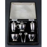 A silver five-piece condiment set of slender ovoid design, comprising a pair of pepper pots, a