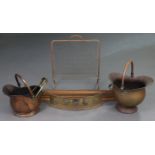 Two 19th century copper helmet-shaped coal scuttles; two pierced brass fenders; a mesh firescreen; &