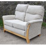 A light oak-frame two-seater settee (purchased from T. R. Hayes of Bath) with loose cushions to