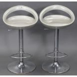 A pair of silvered plastic & silvered-metal bar stools.