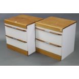 A pair of teak & white laminate two-drawer bedside chests, 19¾” wide x 21” high x 17¾” deep.