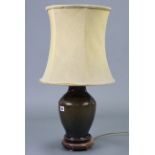 A dark celadon glazed pottery ovoid table lamp with shade, (25¼” tall overall).
