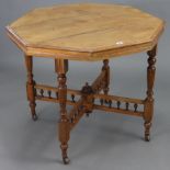 A late Victorian mahogany octagonal centre table, on four fluted & turned legs with ceramic castors,