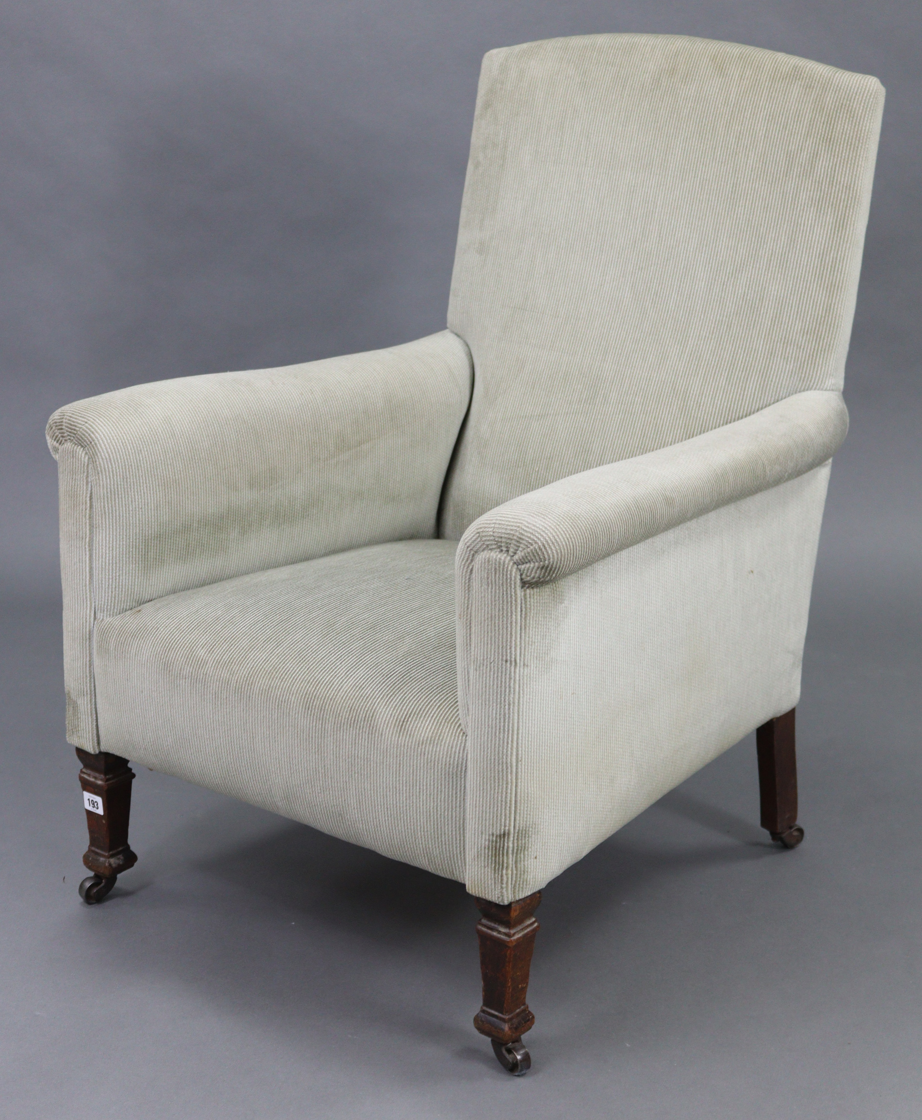 An Edwardian armchair upholstered grey velour, & on short square legs with steel castors.