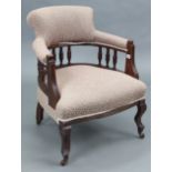 An Edwardian tub-shaped easy chair with spindle-rail to the back, upholstered foliate material &