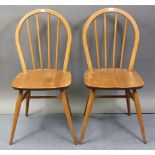 A pair of Ercol spindle-back kitchen chairs with hard seats, & on round tapered legs with spindle