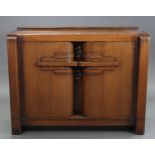 A 1930’s E.GOMME OAK SIDEBOARD with fitted interior enclosed by pair of panel doors, & on square end