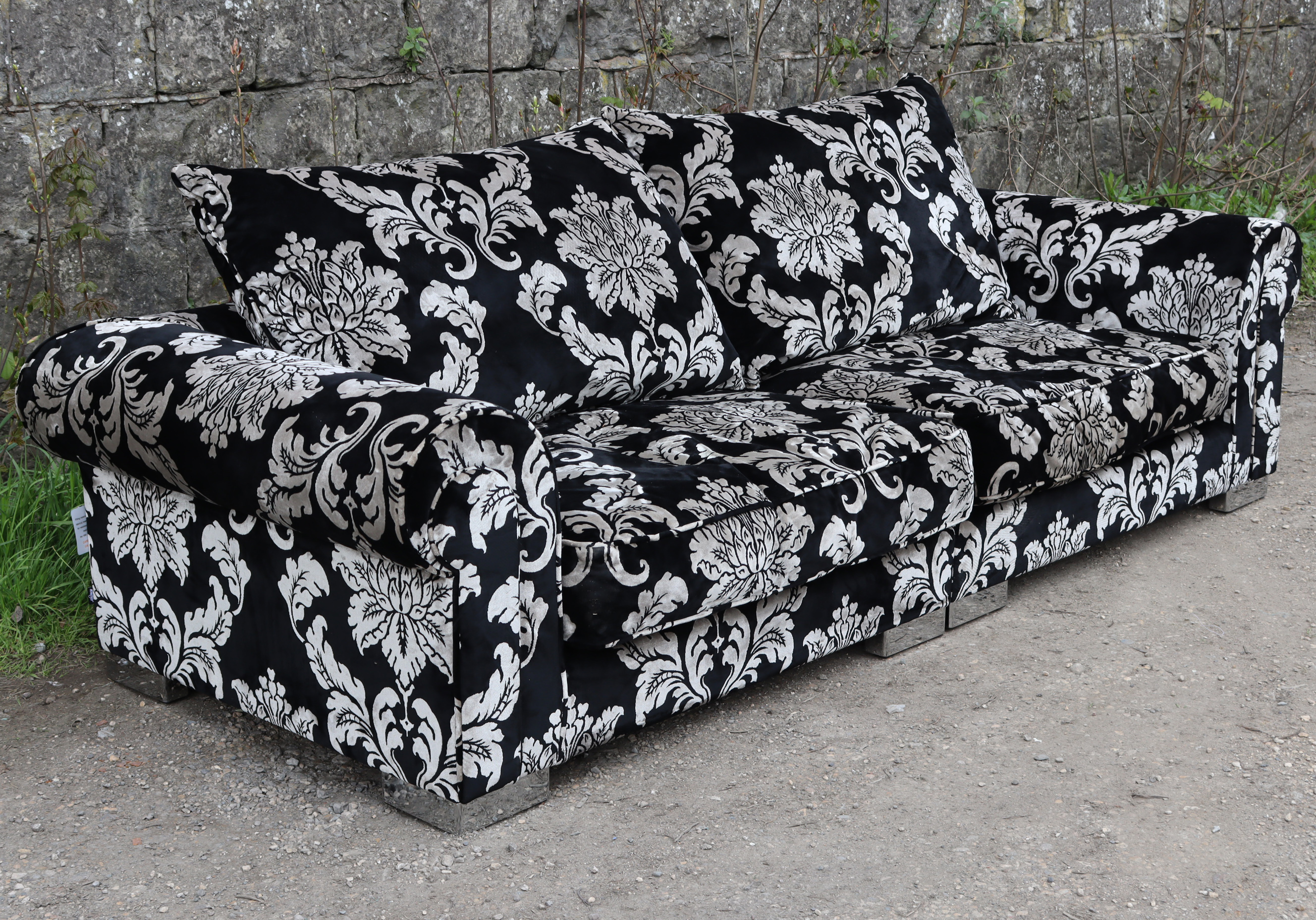 A modern four-seater settee with scroll-arms & with loose cushions to the seat & back upholstered