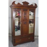 A Victorian walnut wardrobe with carved & shaped cornice with carved centre panel flanked by