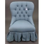 A Laura Ashley buttoned-back nursing chair, upholstered blue material & on turned legs.
