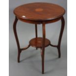 An Edwardian inlaid-mahogany circular two-tier occasional table on four slender cabriole legs, 24”