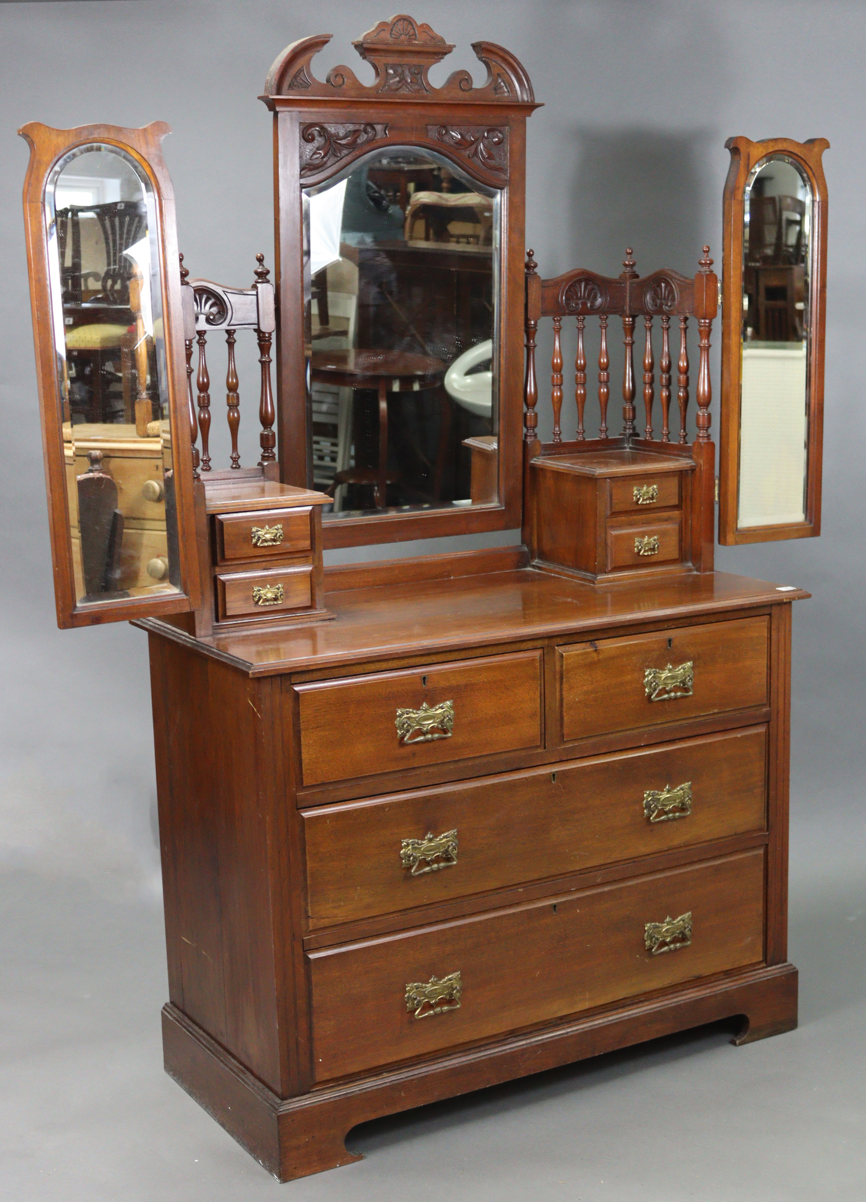 A Victorian walnut dressing chest with three mirrors to the stage back, fitted two short & two