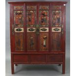 A Chinese red lacquered pine tall side cabinet with fitted interior enclosed by two pairs of