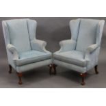 A pair of wing-back armchairs, upholstered pale blue velour & on short cabriole legs claw-&-ball