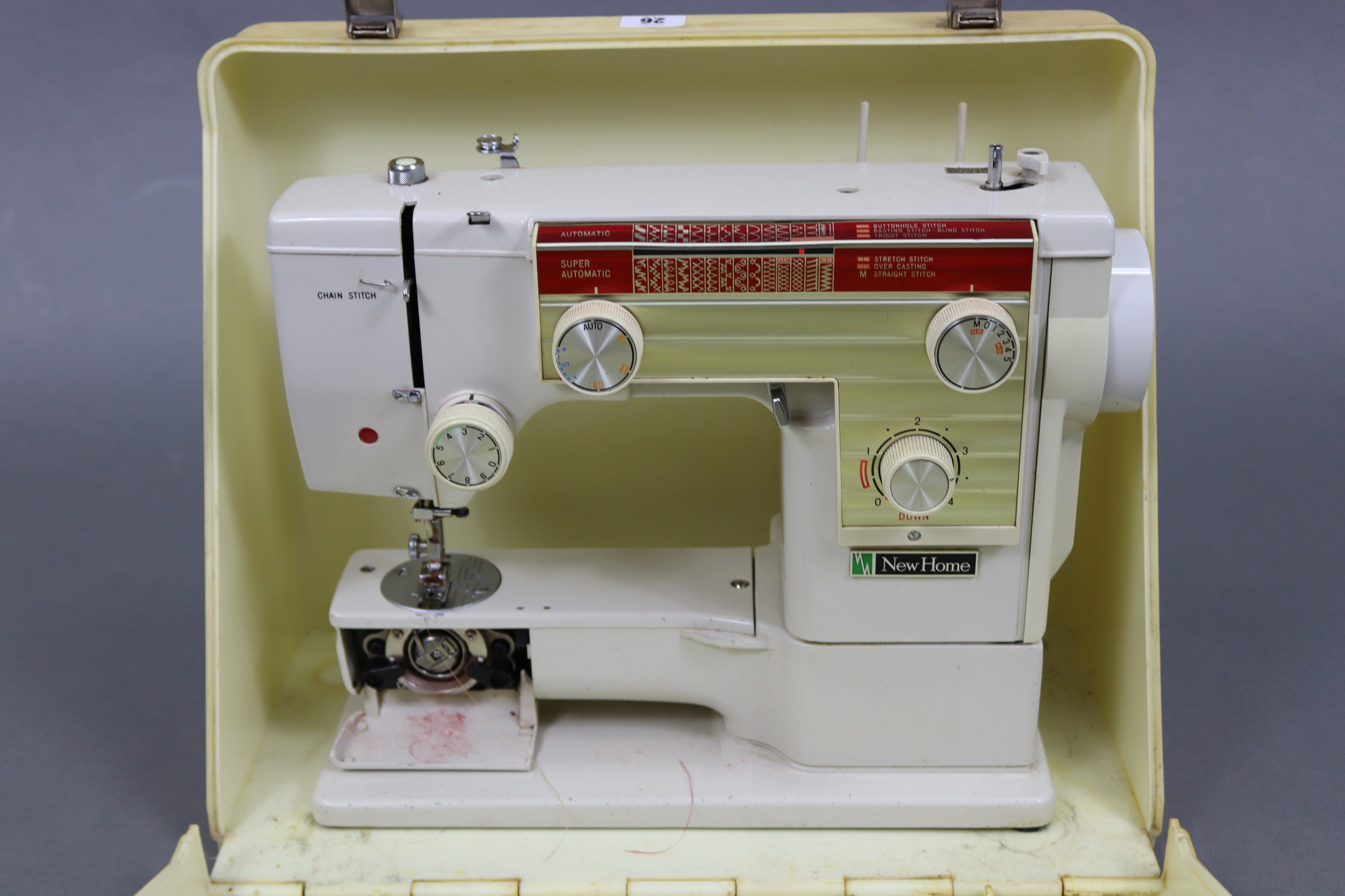 A New Home electric sewing machine with case.