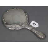 An Edwardian embossed & engraved silver-backed hand mirror, 11” long, Birmingham 1907.