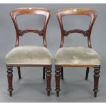 A pair of Victorian mahogany balloon-back dining chairs, each with carved & shaped centre rail,