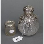 An Edwardian cut-glass globular scent bottle with embossed & pierced silver mount, 5¾” high,