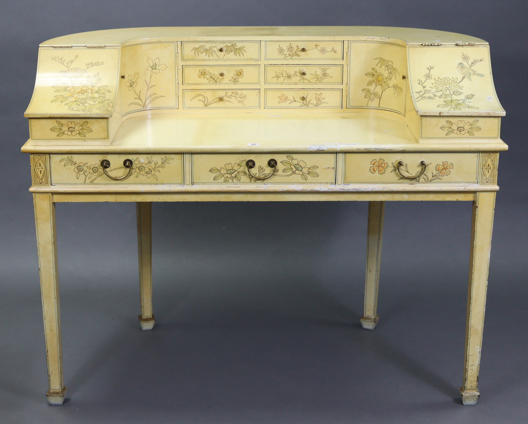 A Carlton House-type cream finish wooden desk, fitted with an arrangement of small drawers &
