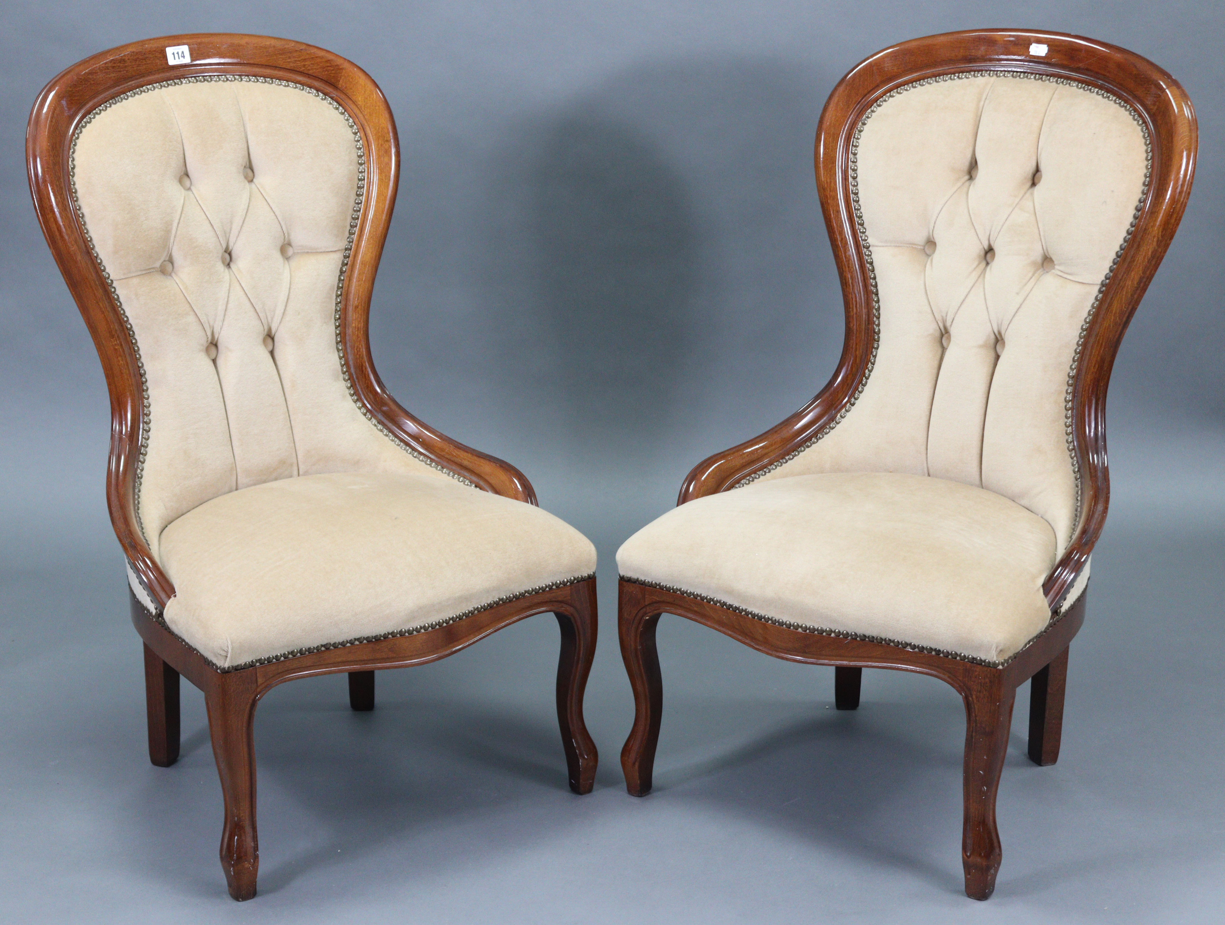 A pair of Victorian-style spoon-back easy chairs each with sprung seat & buttoned-back upholstered