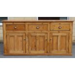 A Victorian-style pine dresser base, fitted three frieze drawers above cupboard enclosed by three