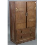 A mid-20th century light oak millinery cupboard, fitted two shelves enclosed by a pair of carved