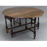 An oak oval gate-leg dining table fitted end drawer, & on baluster-turned legs & turned feet with