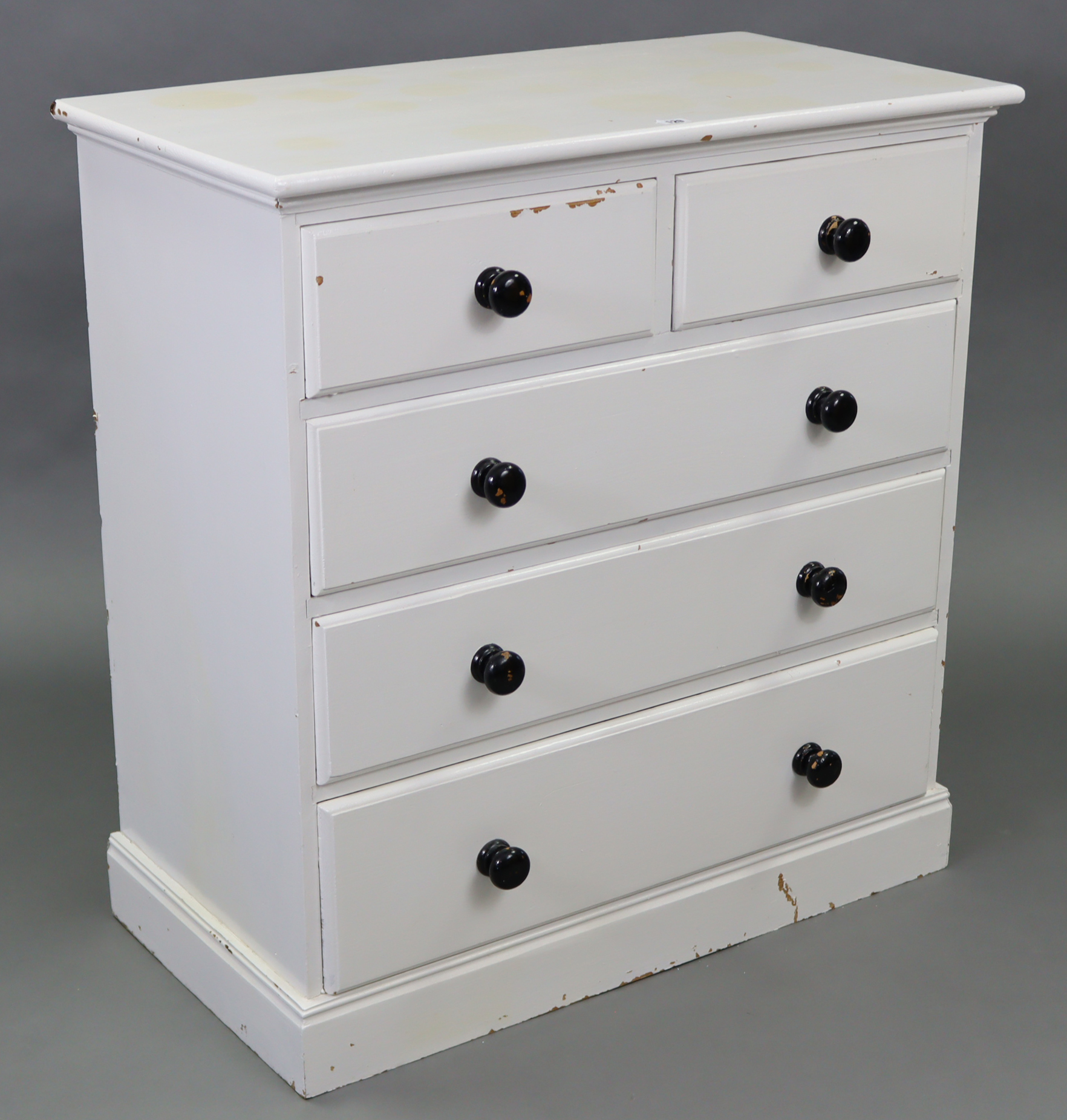 A white painted pine chest fitted two short & three long graduated drawers with turned knob handles,