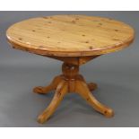 A pine circular extending pedestal dining table, with centre leaf & on vase-turned centre column &