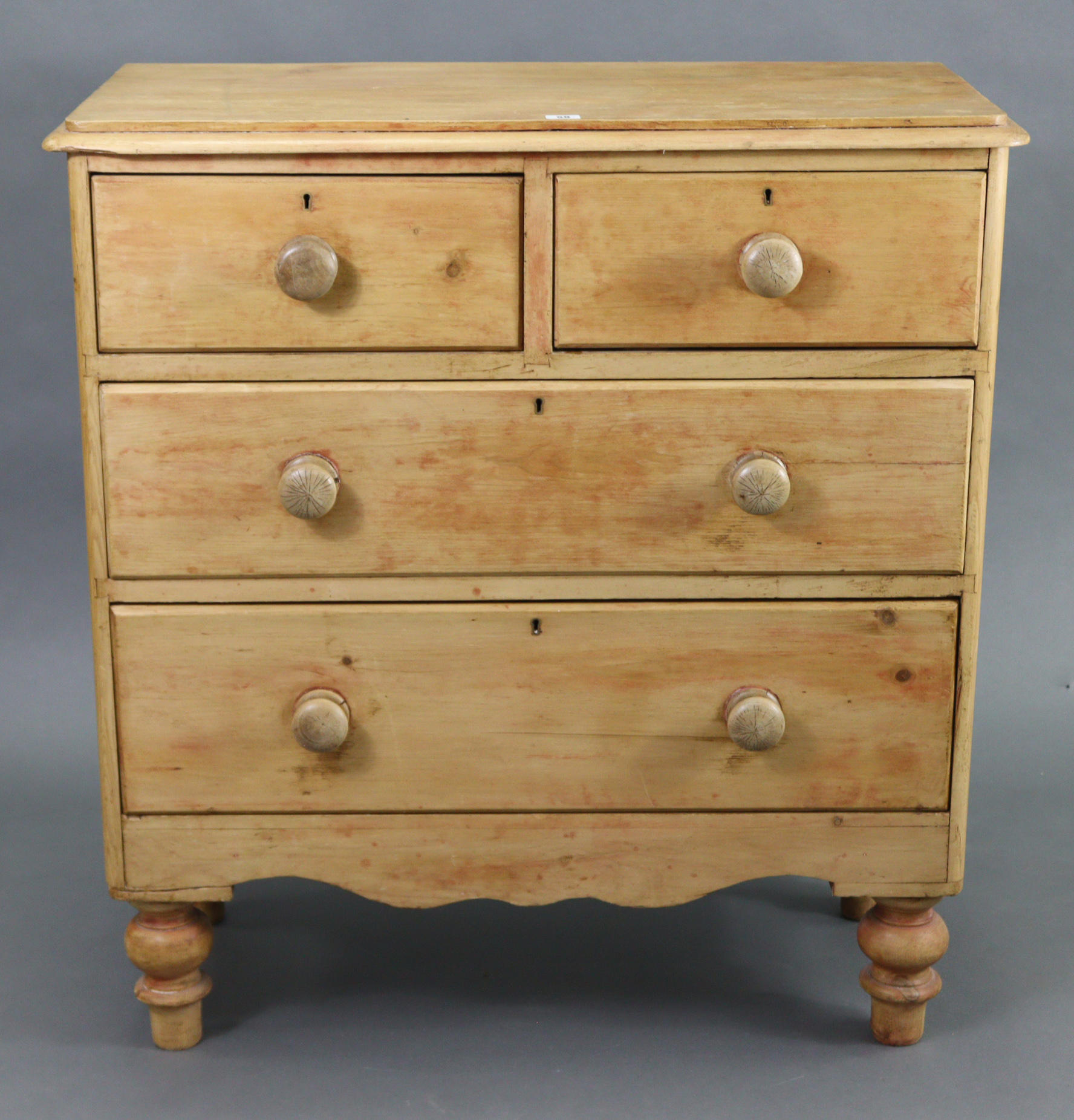 A pine chest fitted two short & two long graduated drawers with turned knob handles, & on short