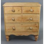 A pine chest fitted two short & two long graduated drawers with turned knob handles, & on short