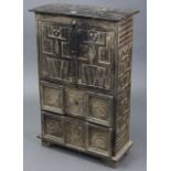 A Peruvian-style ebonised wooden small upright cabinet with all-over carved figure-scene decoration,